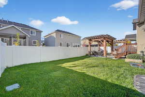Fenced backyard with a patio, a pergola, and a residential view