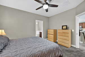 Carpeted bedroom featuring a ceiling fan and baseboards