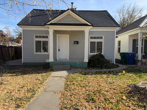 View of front facade with roof with shingles and covered porch