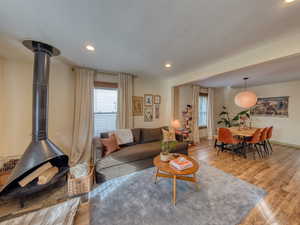 Living area with wood finished floors, recessed lighting, and a wood stove