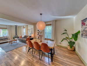 Dining space featuring wood finished floors and a wood stove