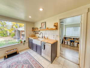 Kitchen with dishwasher, open shelves, tasteful backsplash, plenty of natural light, and recessed lighting