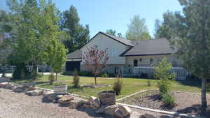 View of front of property featuring a shingled roof, stucco siding, and covered porch