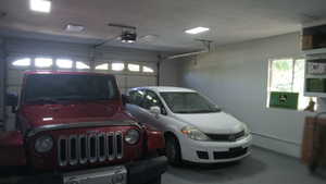 Garage with a baseboard heating unit and a garage door opener
