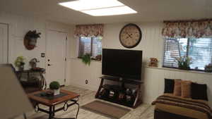 Living area with light wood-style floors and wooden walls