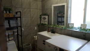 Bathroom featuring vanity and tile walls