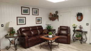 Living area with wood finished floors and wooden walls