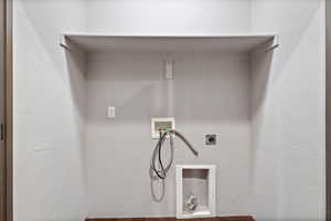 Washroom with a textured wall, hookup for a washing machine, and hookup for an electric dryer