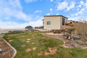 View of grassy yard with a storage shed