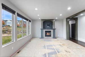 Unfurnished living room featuring recessed lighting, a tile fireplace, and arched walkways