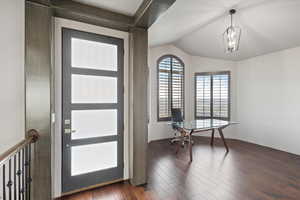 Foyer entrance with dark wood finished floors and lofted ceiling