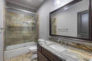 Bathroom with shower / bath combination with glass door and vanity