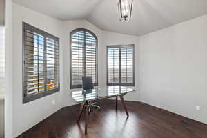 Office space featuring vaulted ceiling and dark wood-style floors