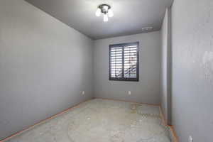 Unfurnished room featuring a textured wall