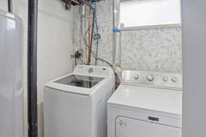 Washroom featuring water heater and independent washer and dryer