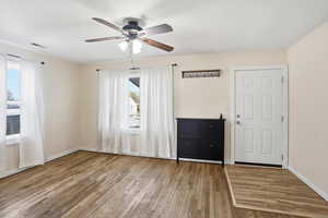 Empty room with light wood-style flooring and ceiling fan
