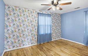 Empty room featuring hardwood / wood-style floors and a ceiling fan