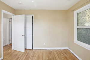 Unfurnished bedroom with light wood-style flooring and baseboards