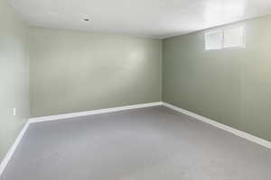 Empty room with finished concrete flooring and baseboards