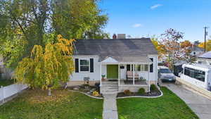View of front of home with a chimney and a shingled roof