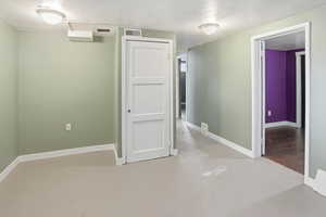 Hallway with baseboards and concrete flooring
