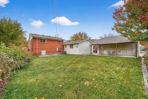 Rear view of property with a patio and a yard