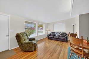 Living area with light wood-style flooring and vaulted ceiling