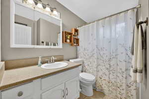 Full bathroom featuring vanity, a shower with curtain, and light tile patterned floors