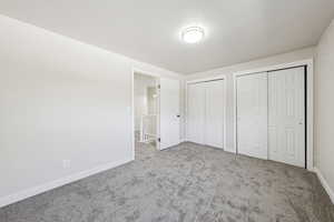 Unfurnished bedroom featuring multiple closets and carpet
