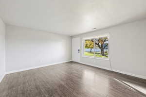 Empty room featuring wood finished floors and a textured ceiling