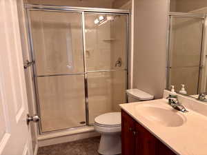 Bathroom with vanity, a stall shower, and tile patterned floors