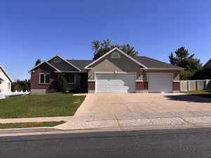 Home featuring brick siding, driveway, and an attached 3 car garage