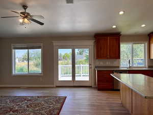 Kitchen featuring brown cabinets, dishwasher, recessed lighting, light wood finished floors, and a textured ceiling