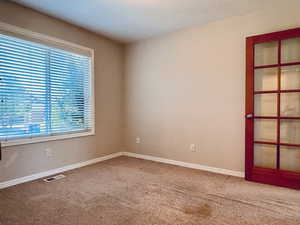 Bedroom or office featuring carpet and baseboards