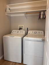 Laundry area featuring light wood-style floors and washing machine and clothes dryer