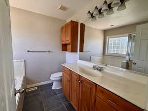 Master bathroom with vanity, a bath, a shower stall, and dark tile patterned flooring