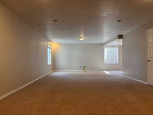 Carpeted living room featuring baseboards and a textured ceiling