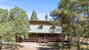Log home featuring covered porch and a metal roof