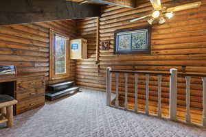 Interior space featuring carpet flooring and rustic walls