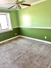 Empty room featuring carpet, a textured ceiling, ceiling fan, and crown molding