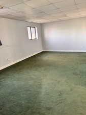 Unfurnished room with a drop ceiling and carpet