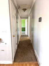 Corridor featuring ornamental molding, wood finished floors, and carpet floors