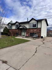 Bi-level home featuring brick siding and a front yard