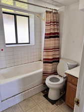 Bathroom with shower / tub combo with curtain, vanity, and light tile patterned floors
