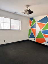 Unfurnished room with a textured ceiling and ceiling fan