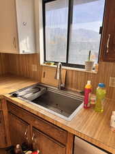 Kitchen featuring light countertops, brown cabinets, wooden walls, and a mountain view