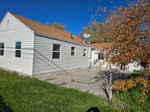 View of side of property featuring a patio and a yard