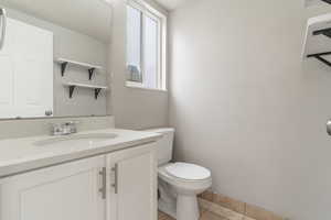 Half bathroom with vanity and light tile patterned floors
