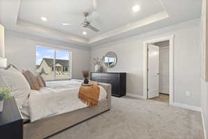 Bedroom with light carpet, a tray ceiling, a ceiling fan, and recessed lighting