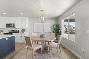 Dining area with light wood-type flooring, a chandelier, and recessed lighting